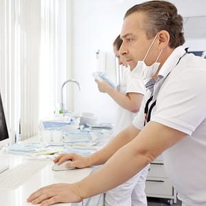 Dentist looking at an xray on a computer - dental cyber liability insurance